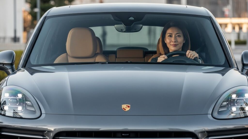 港区エリアで左ハンドルのポルシェを運転する女性。ペーパードライバー講習を通じて、日常の移動手段として外車を無理なく使えているイメージ。